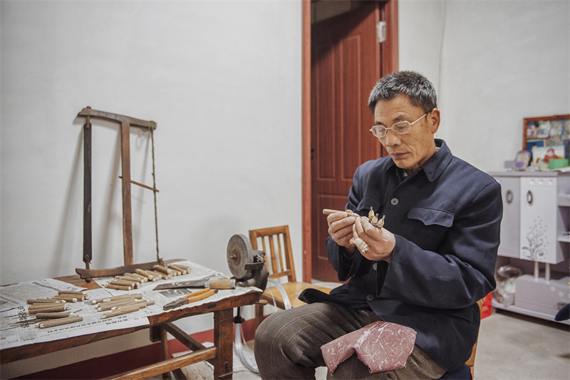 Folk artist creates Spring Festival paper carving works in E China's Shandong