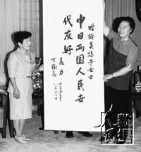 Nie Li (right) presents Kato Mihoko a calligraphic work.
