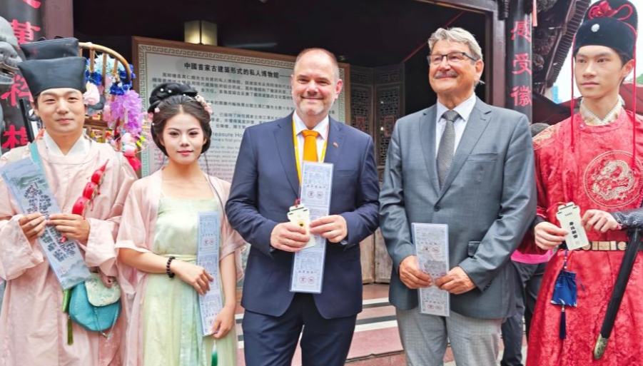 Guests attending Global Mayors Dialogue event experience Chinese culture in Huangshan 	 	This photo taken with a mobile phone shows Alexander Badrow (C), mayor of Stralsund, and Peter Paul (R), president of the Stralsund City Council, striking a bell on a traditional culture street in Huangshan, east China's Anhui Province, on May 28, 2026. 