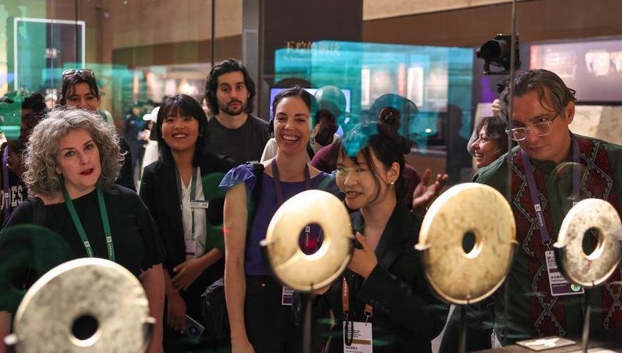 Feature: Bilingual volunteers bridge cultures to share 5,000-year story of Chinese civilization 	 	Visitors try out a multilingual AI transparent screen capable of real-timClad in a red volunteer vest bearing a badge in the shape of a jade-inlaid lacquer cup, one of her favorite Liangzhu artifacts, American Emma Chen greeted visitors to the Liangzhu Museum in east China, and then shared stories of a civilization that flourished more than 5,000 years ago.