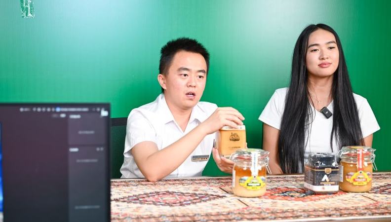 Kyrgyz student gains cross-border trade experience in China's Xinjiang 	 	Zhang Zhaoyang (L), new media manager of the Urumqi Bonded Exhibition and Trading Center, and Datkaiym Alparova introduce honey from Kyrgyzstan at a livestream studio of the Urumqi Bonded Exhibition and Trading Center in Urumqi, northwest China's Xinjiang Uygur Autonomous Region, Sept. 10, 2026. Datkaiym Alparova, who hails from Bishkek, Kyrgyzstan, is majoring in international economics and trade at Xinjiang Normal University. 